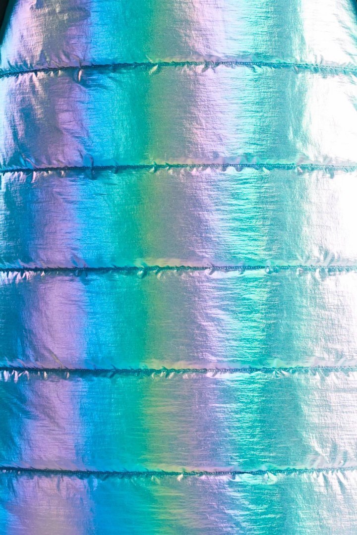 Długa kamizelka damska holograficzna z kapturem zapinana niebieska A386 Długa kamizelka damska holograficzna z kapturem zapinana niebieska A386