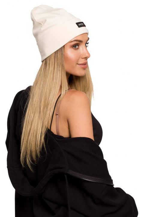 Czapka typu beanie z wywynięciem i naszywką śmietankowa me624 Czapka typu beanie z wywynięciem i naszywką śmietankowa me624
